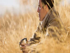 Mansittingingrass-930x401